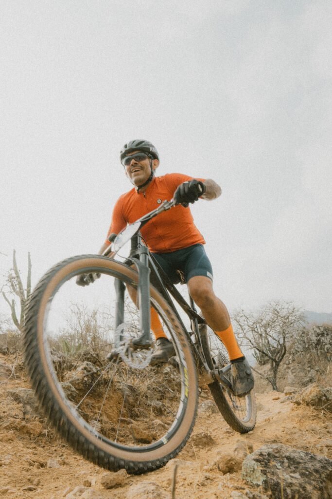 A cyclist rides a mountain bike energetically on a rugged outdoor trail, capturing the thrill of adventure.