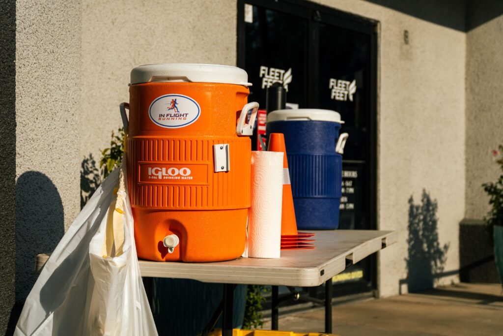 Bright outdoor scene with orange and blue water coolers at Fleet Feet store in Houston, TX.