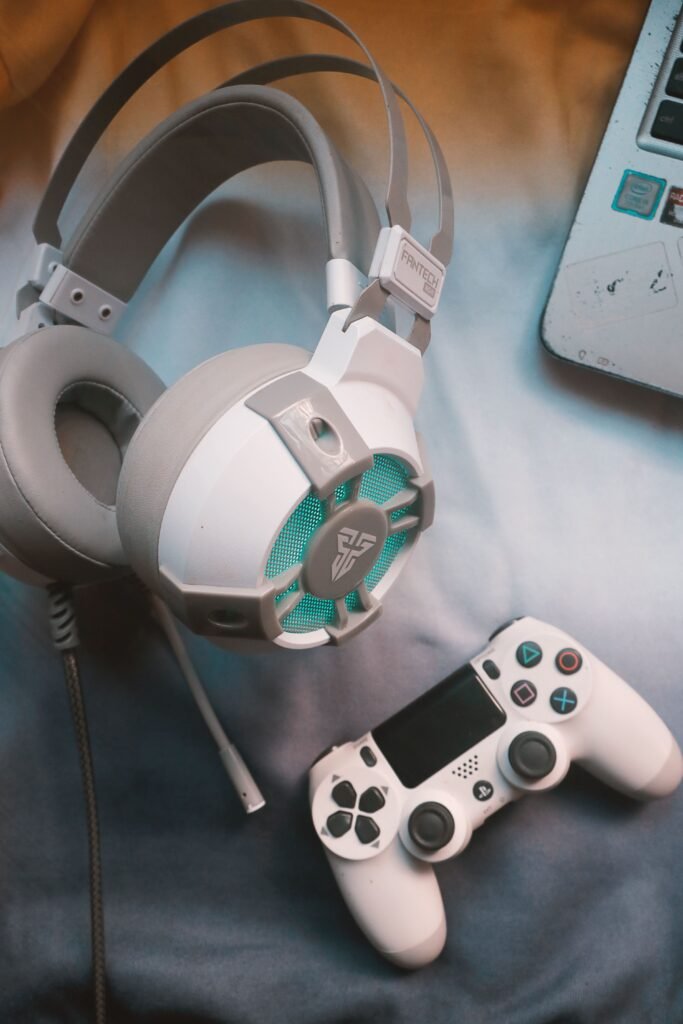 Close-up of gaming headphones and a controller on a desk.
